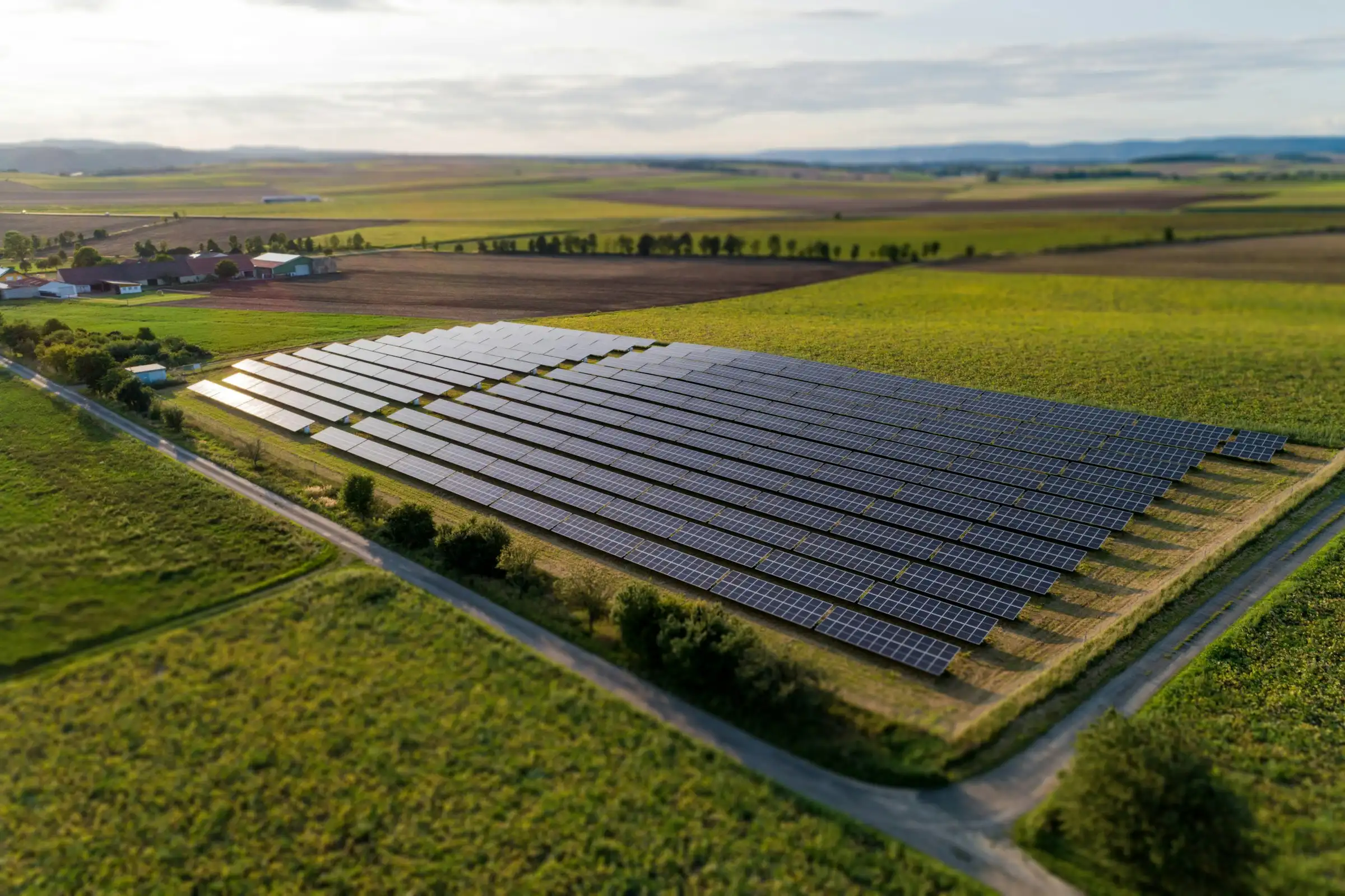 Aerial view of a solar farm among green fields and hedgerows