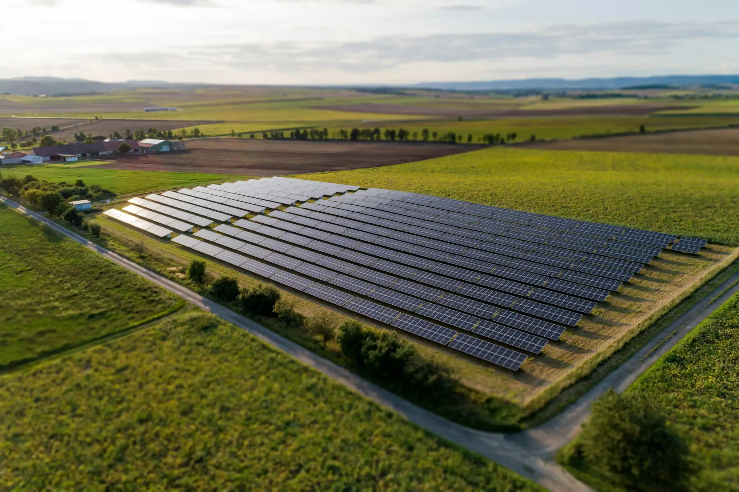 Aerial view of a solar farm among green fields and hedgerows
